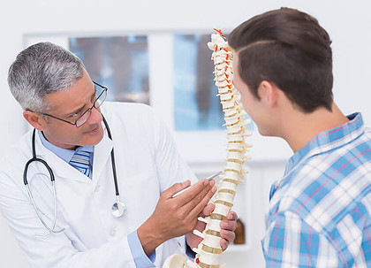 a doctor explaining back pain causes to his patient