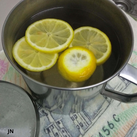 4 slices of lemon in a stainless steel jug filled with boiled water