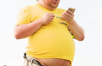 obese man in yellow shirt checking his cellphone