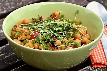 A bowl of green salad with chick peas