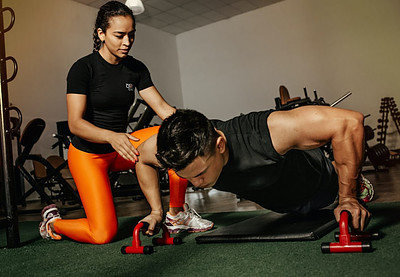 Image photo: A personal trainer is helping a trainer working out
